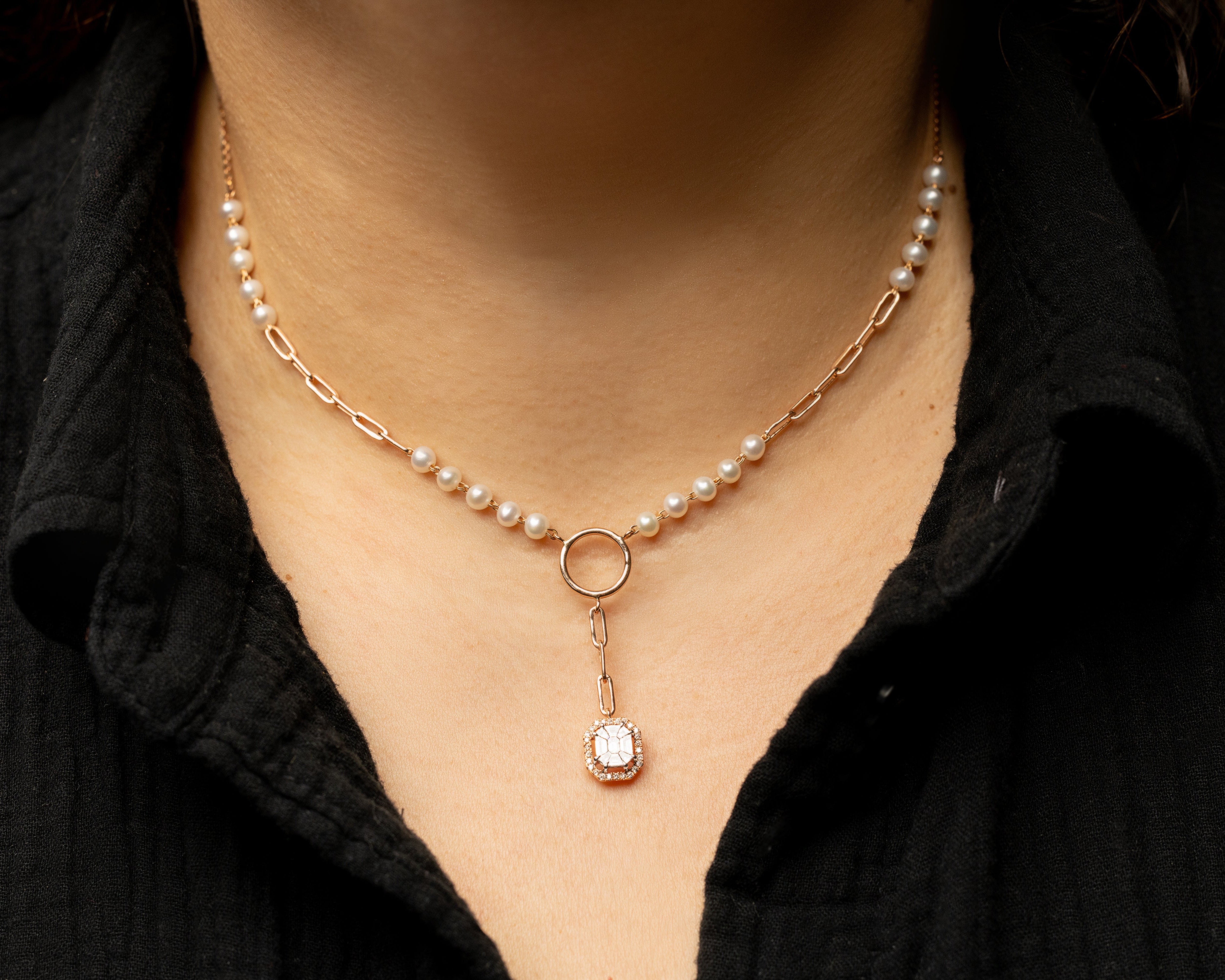 Pearl and diamond solid rose gold necklace with a pendant worn by a person in a black shirt