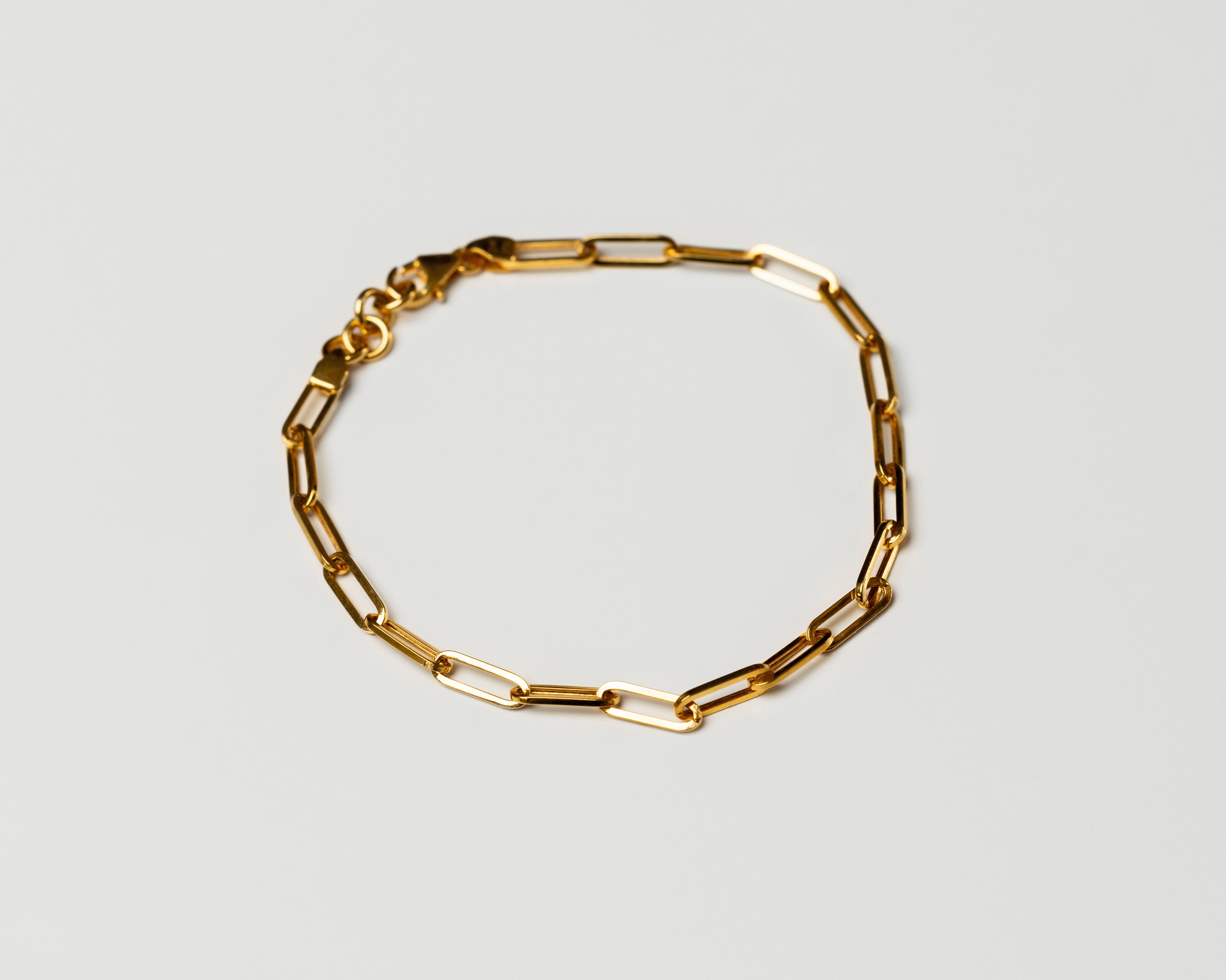 18k solid Gold chain link bracelet on a light gray background