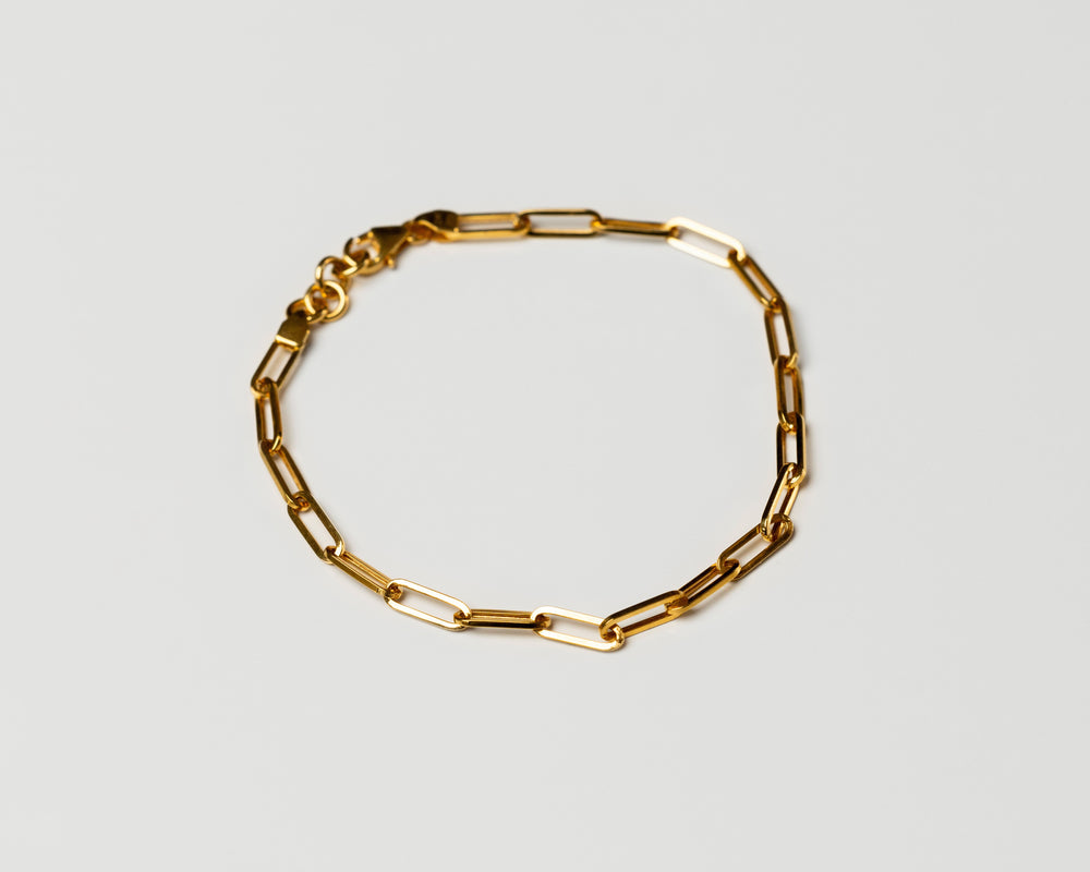 18k solid Gold chain link bracelet on a light gray background