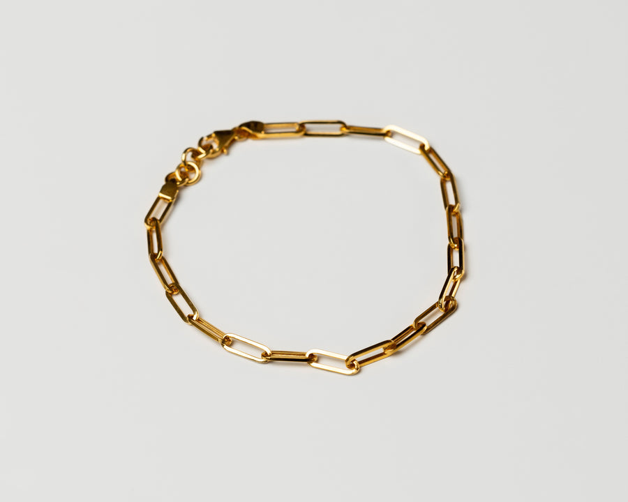 18k solid Gold chain link bracelet on a light gray background