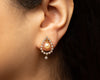 Close-up of an ear wearing a pearl earring with lab grown diamonds with a blurred background