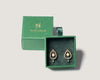 Pair of solid gold diamond earrings with pearls in a green luxury box with brand logo branding on a light gray background